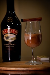 A bottle of booze and a glass of booze on a table