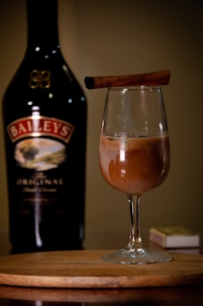 A bottle of booze and a glass of booze on a table