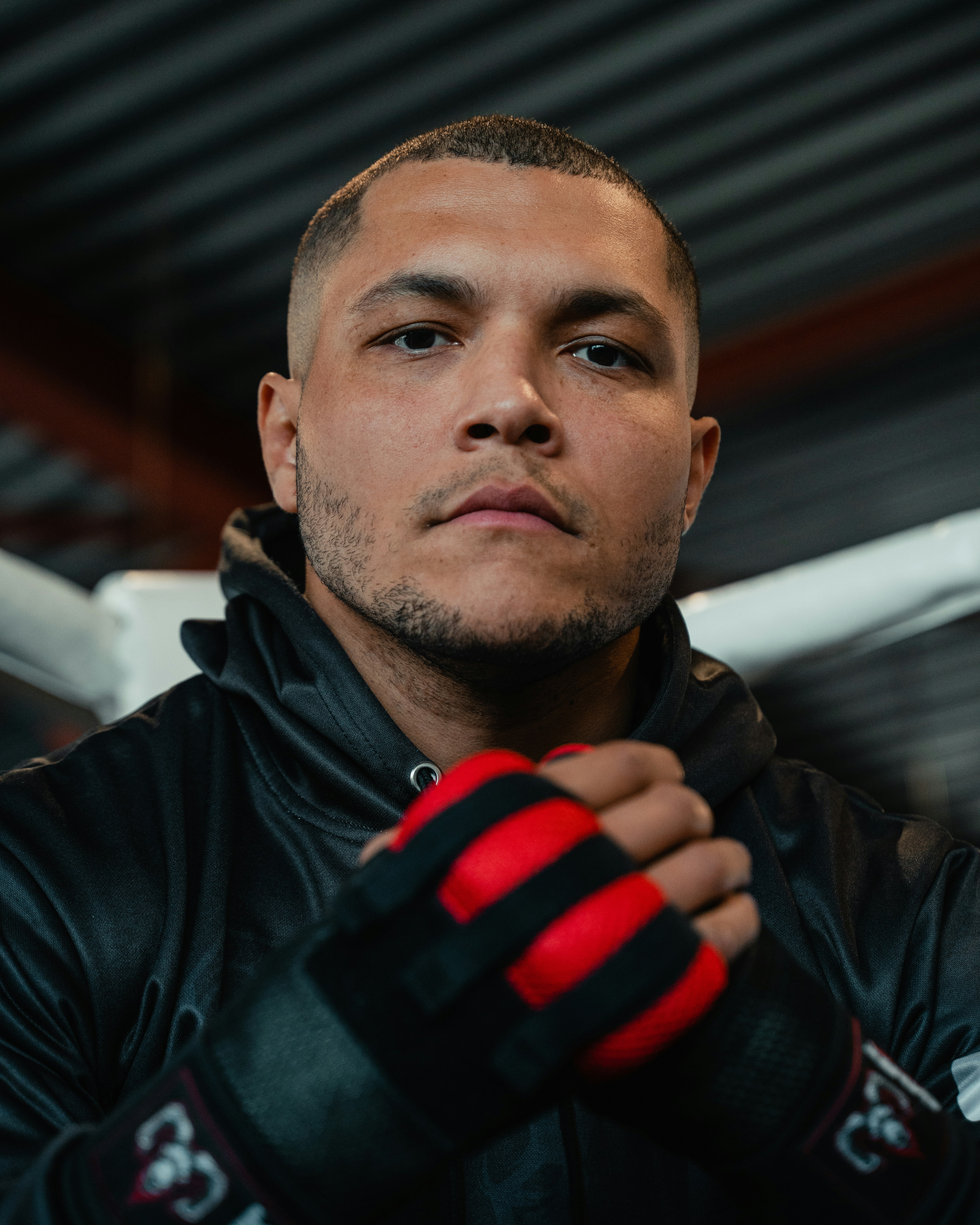 A man in a black jacket and red gloves