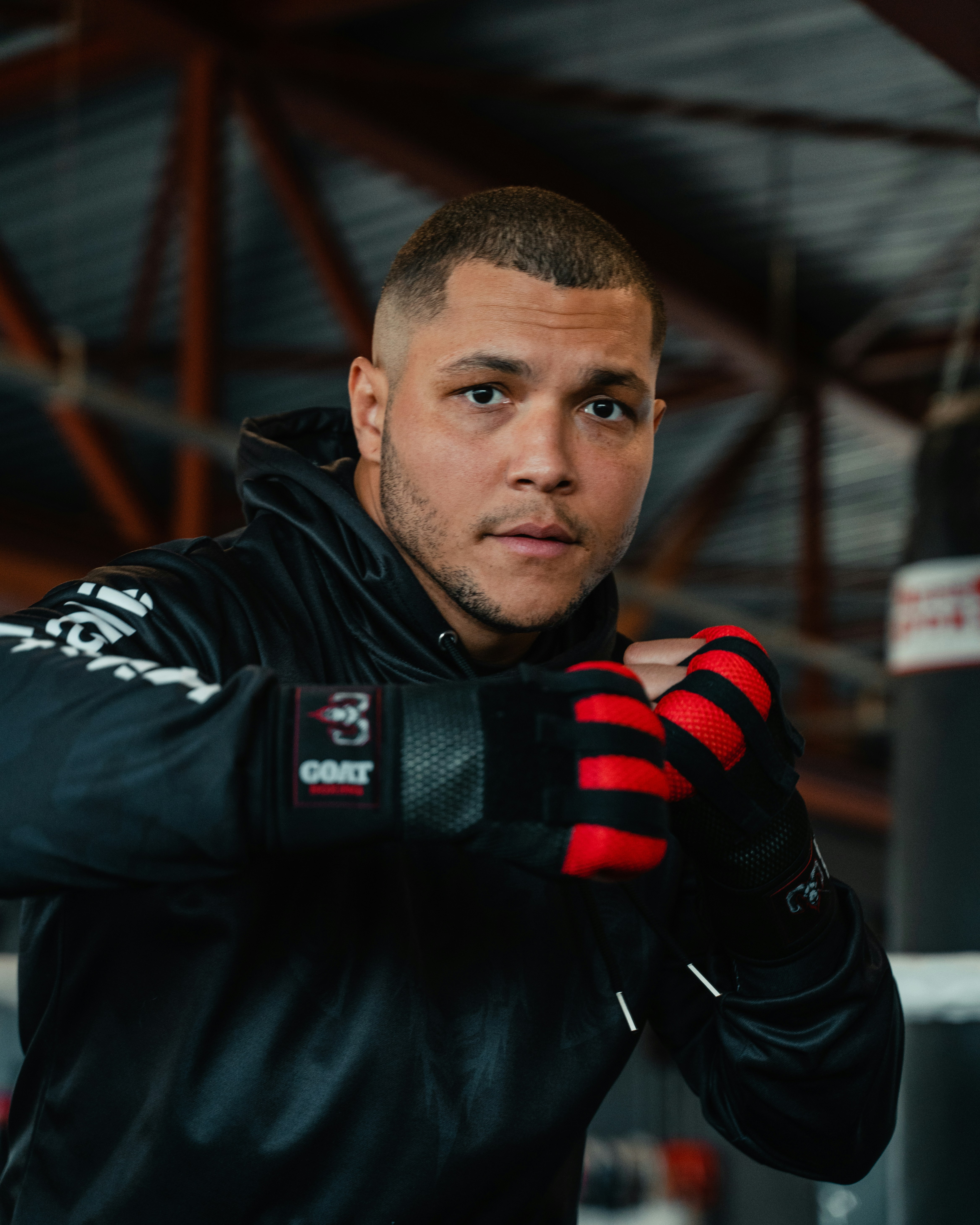 A man in a black jacket and red gloves