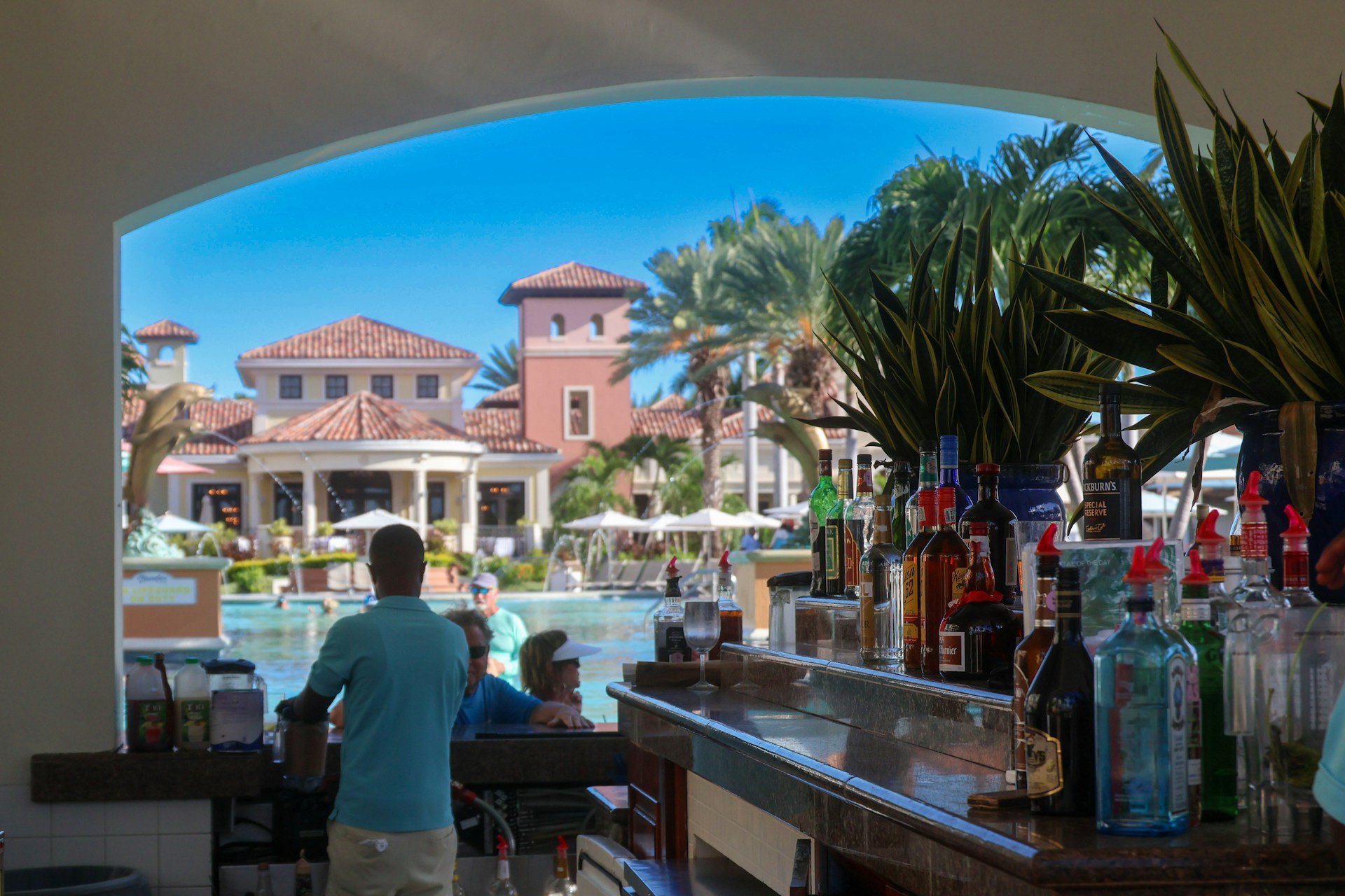 A man standing in front of a bar next to a pool