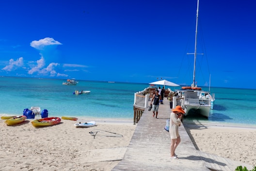A group of people standing on a beach next to a boat