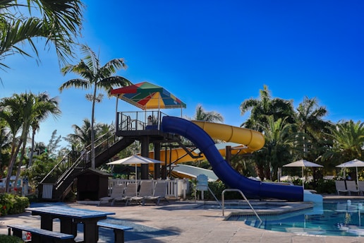 A large water slide next to a swimming pool