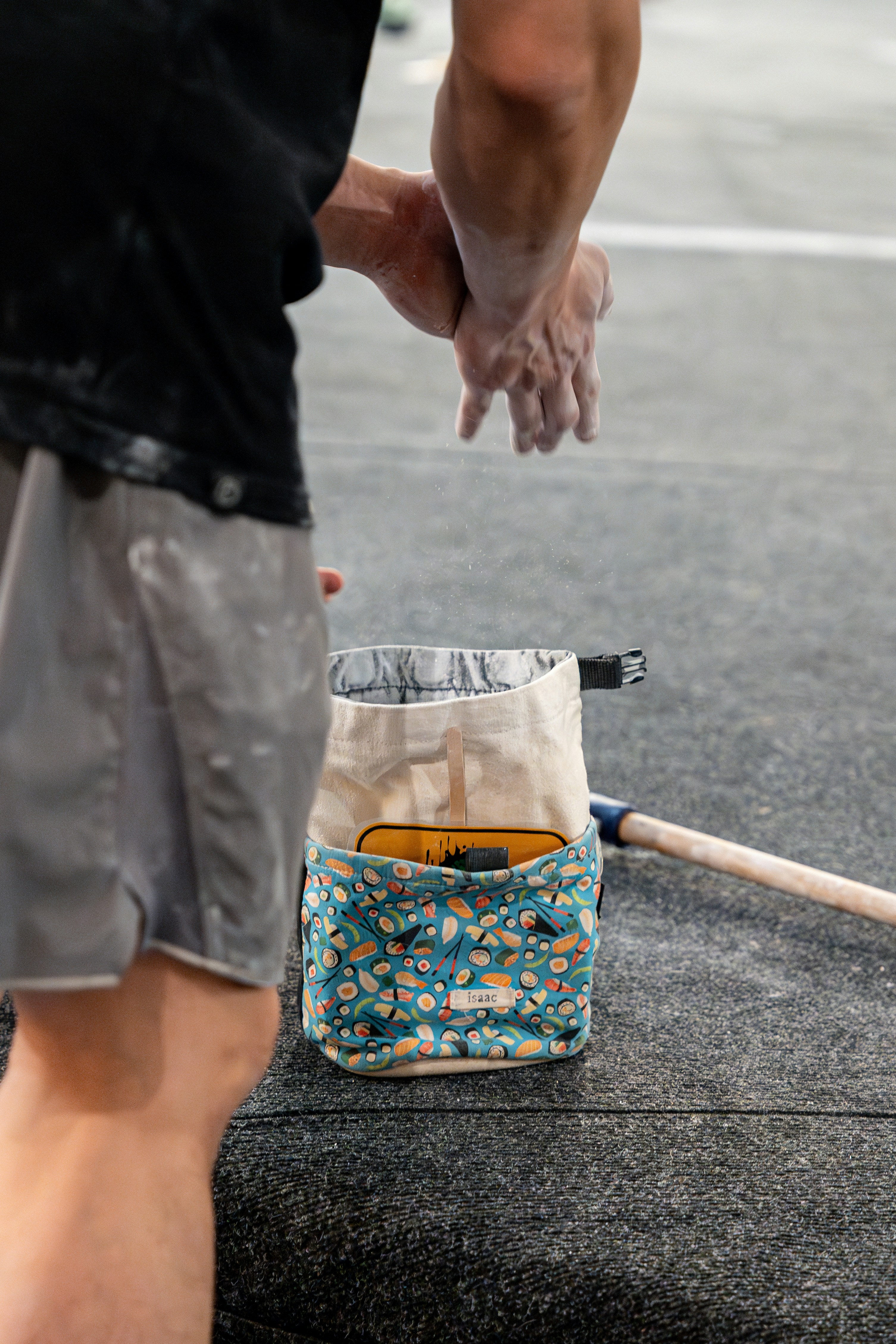 A man standing on a street next to a bag