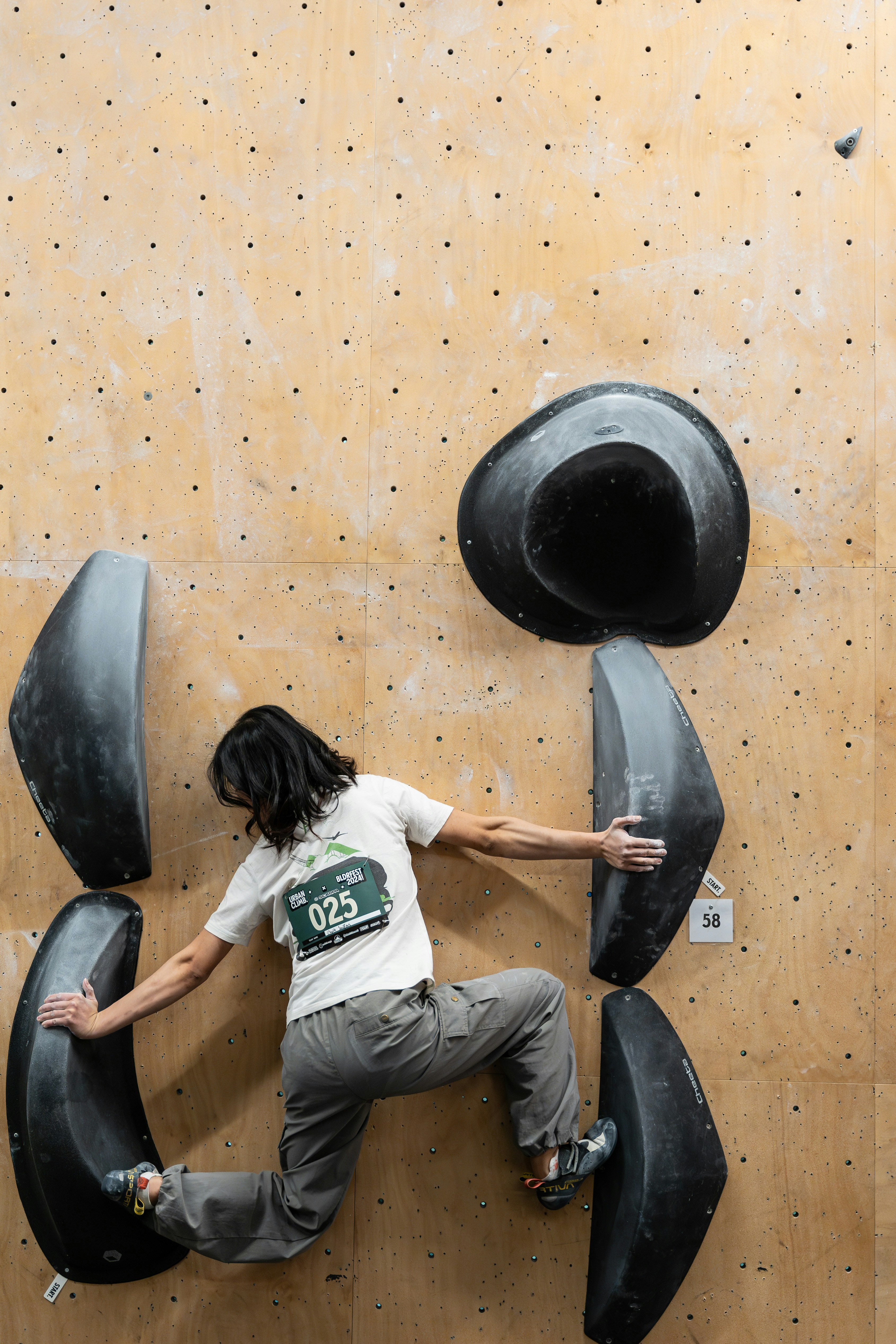A man climbing up the side of a climbing wall