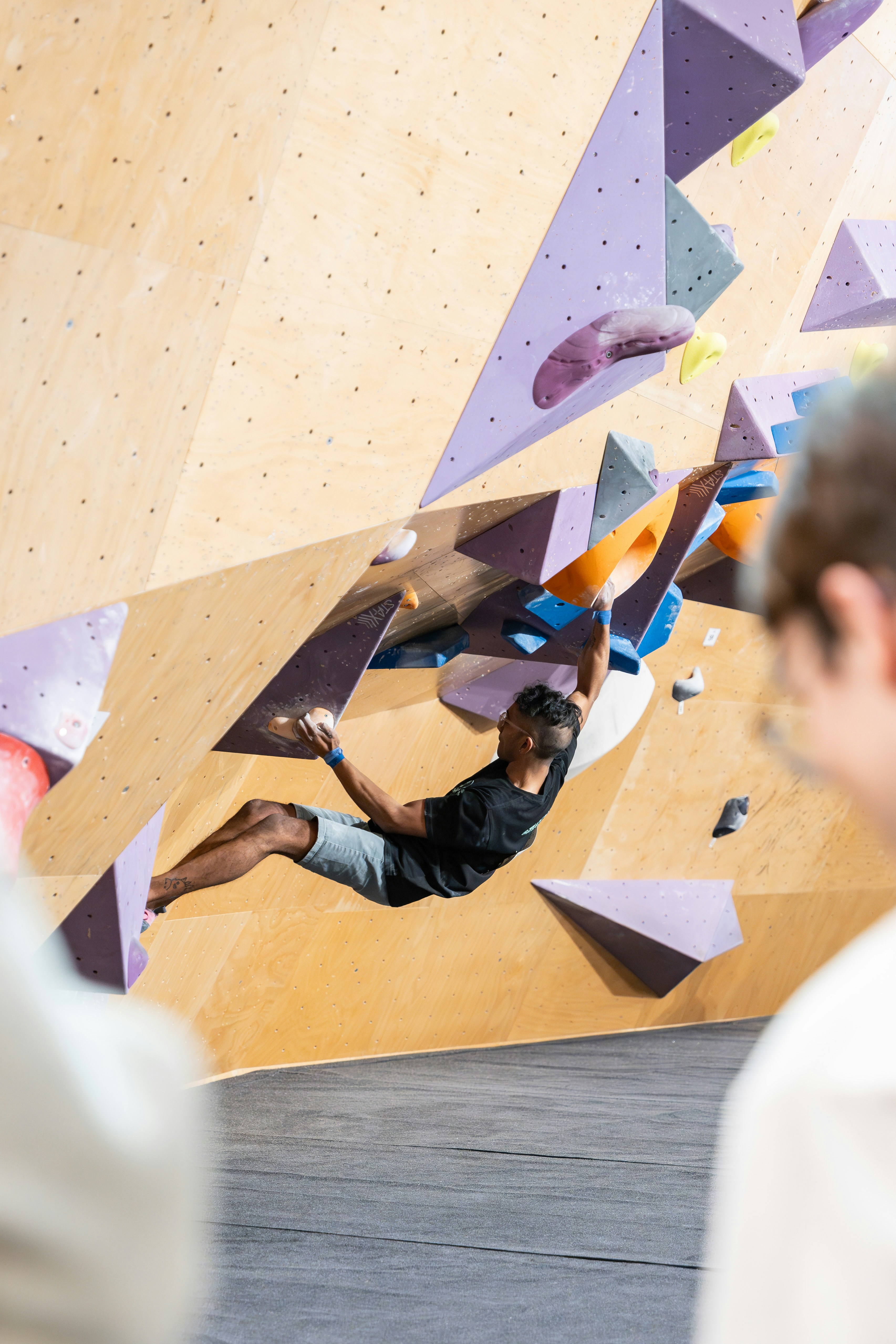 A man is climbing on a climbing wall