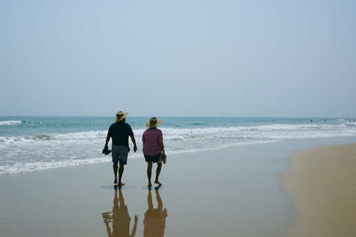 A man and a woman walking on the beach