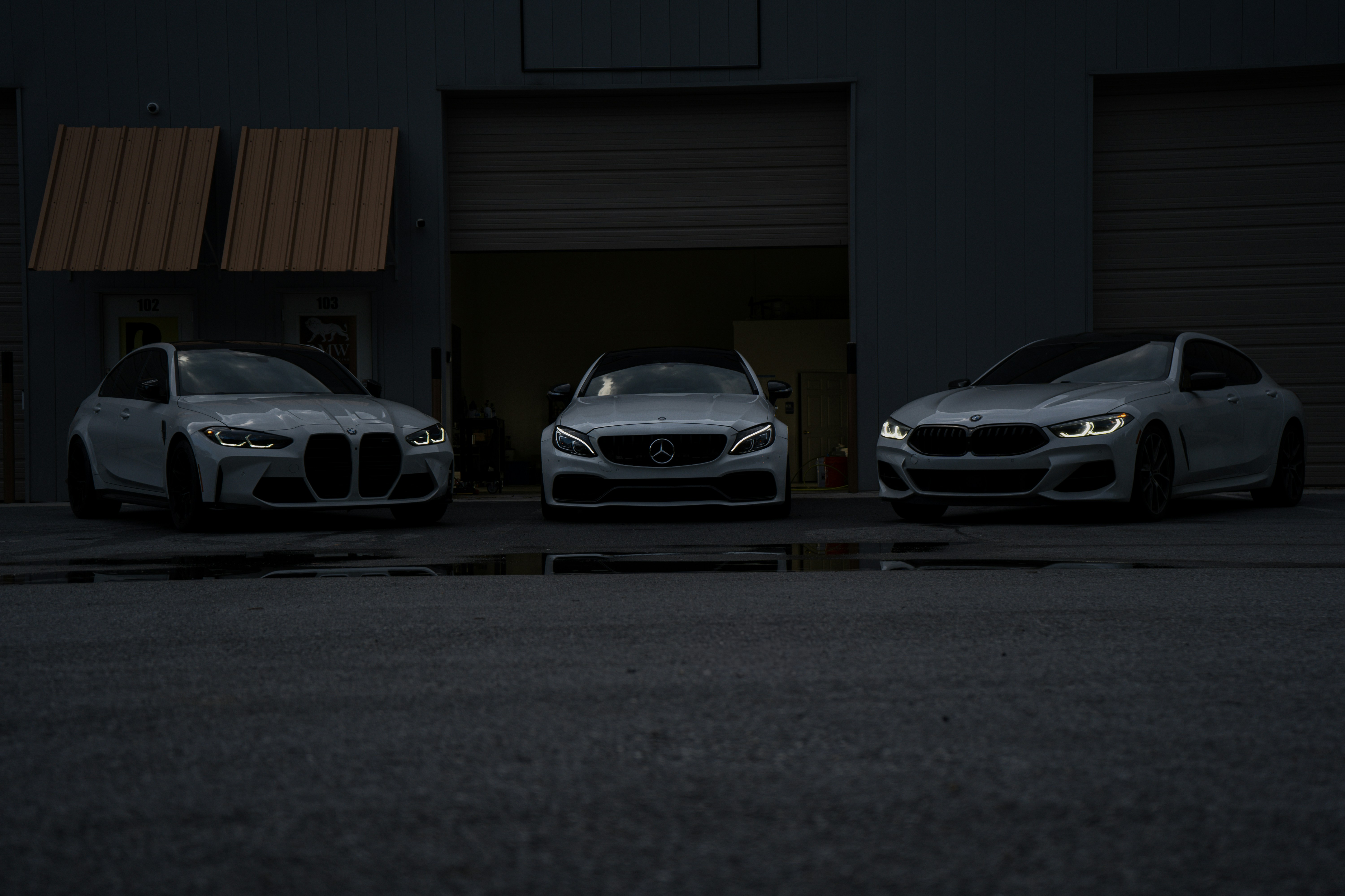 Three cars parked in front of a garage