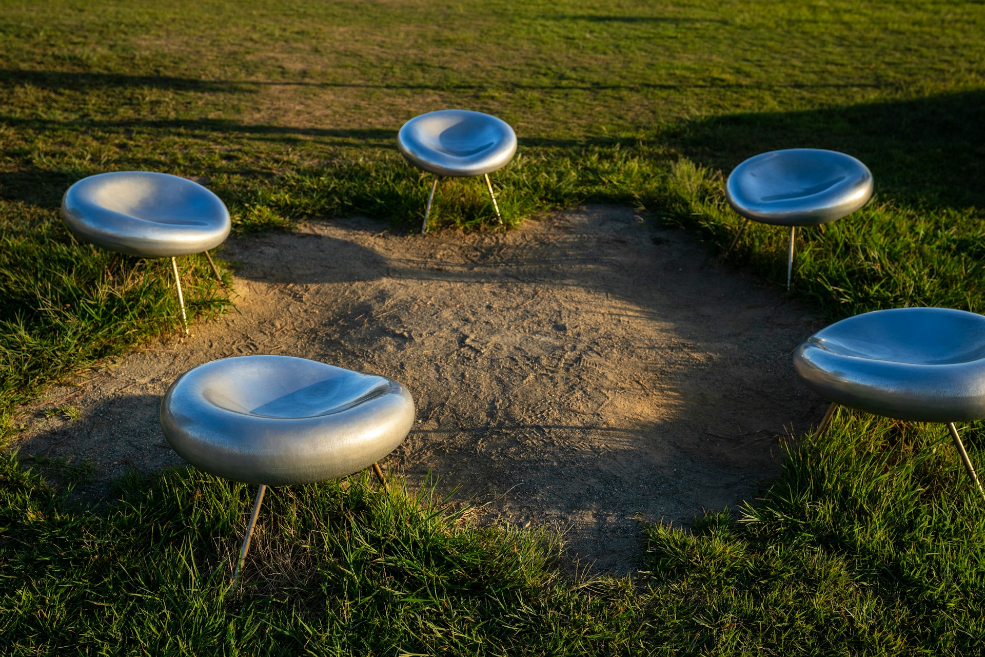 A group of white chairs sitting on top of a lush green field