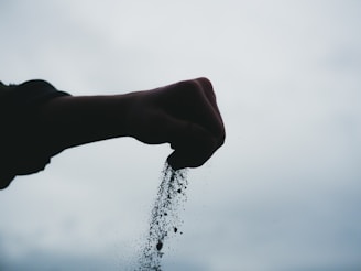 A hand is sprinkling water from a sprinkler