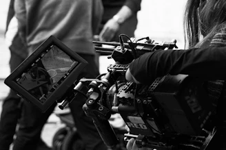 A black and white photo of a person holding a camera