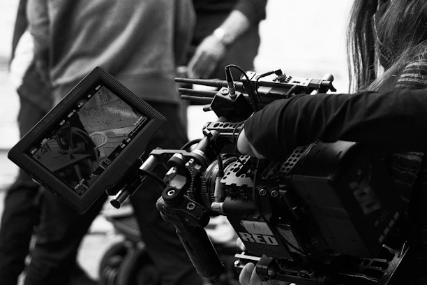 A black and white photo of a person holding a camera