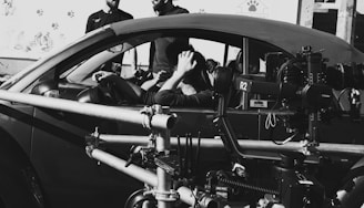 A black and white photo of some people in a car