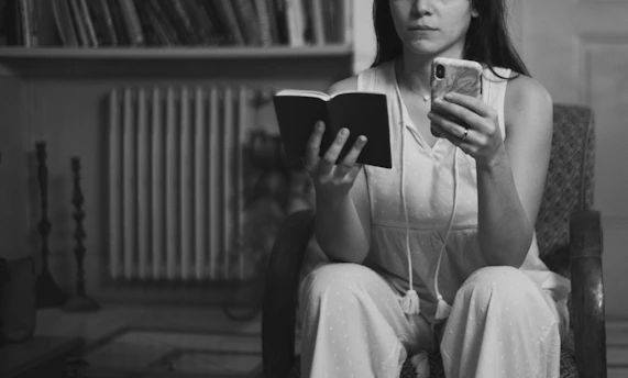 A woman sitting in a chair reading a book