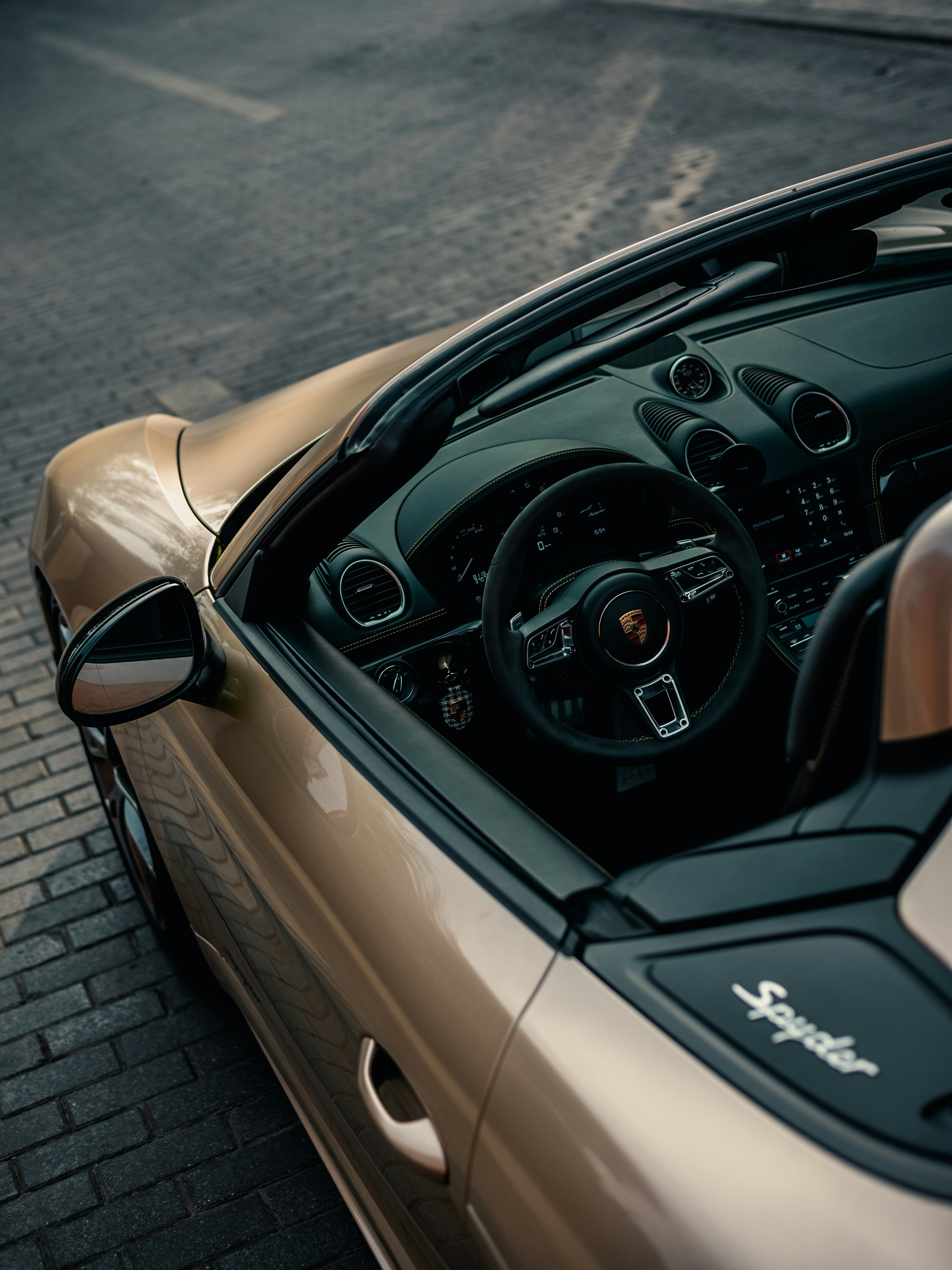 Une voiture de sport dorée garée sur le bord de la route