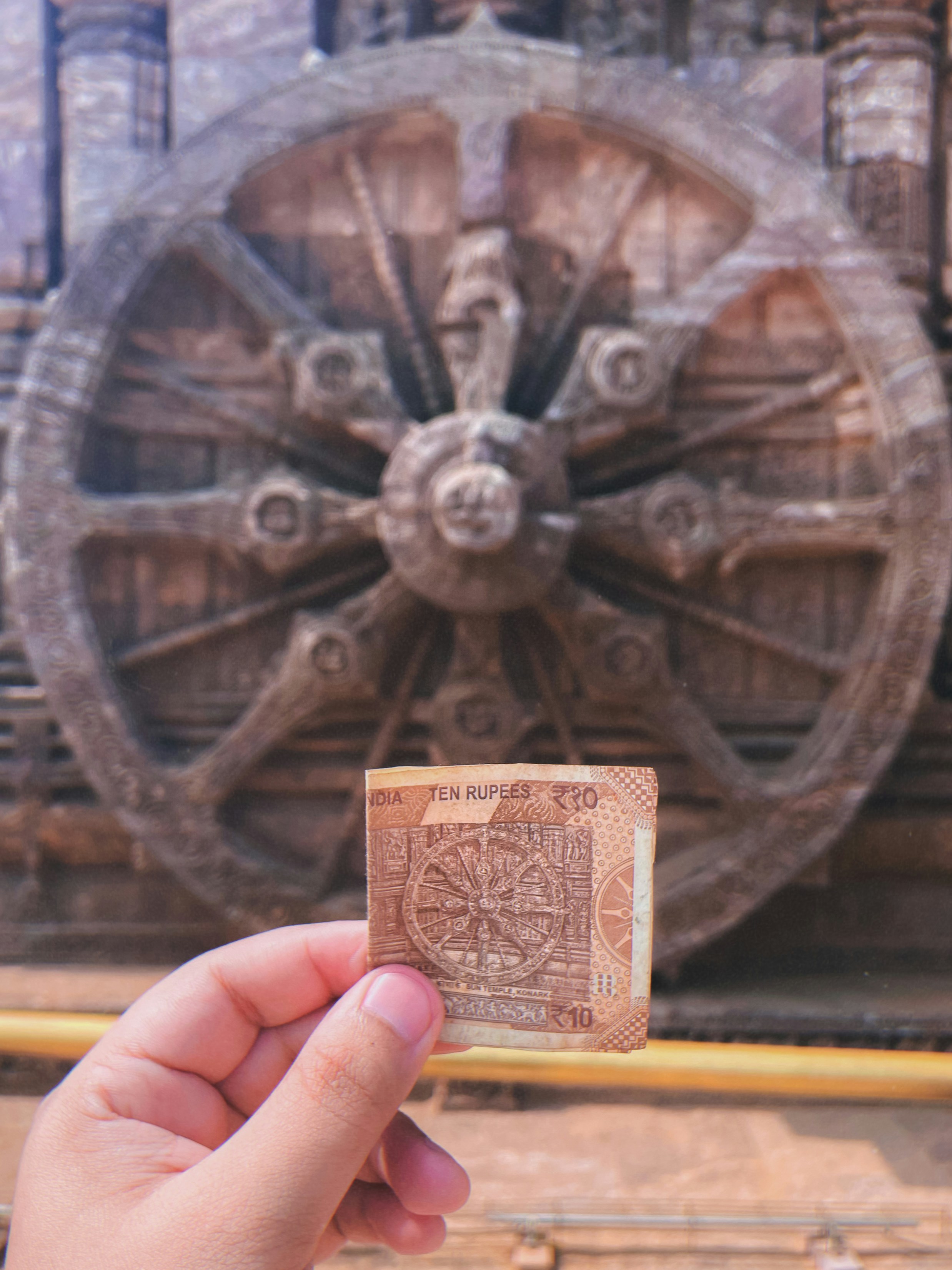 A person holding a piece of paper in front of a wheel