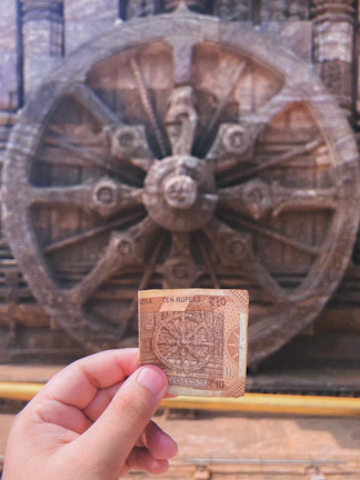 A person holding a piece of paper in front of a wheel