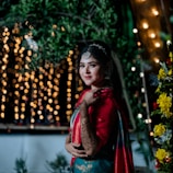 A woman in a red and blue outfit standing in front of a tree