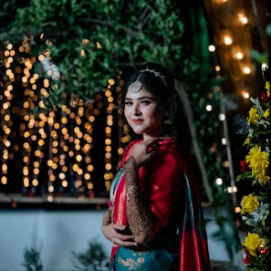 A woman in a red and blue outfit standing in front of a tree