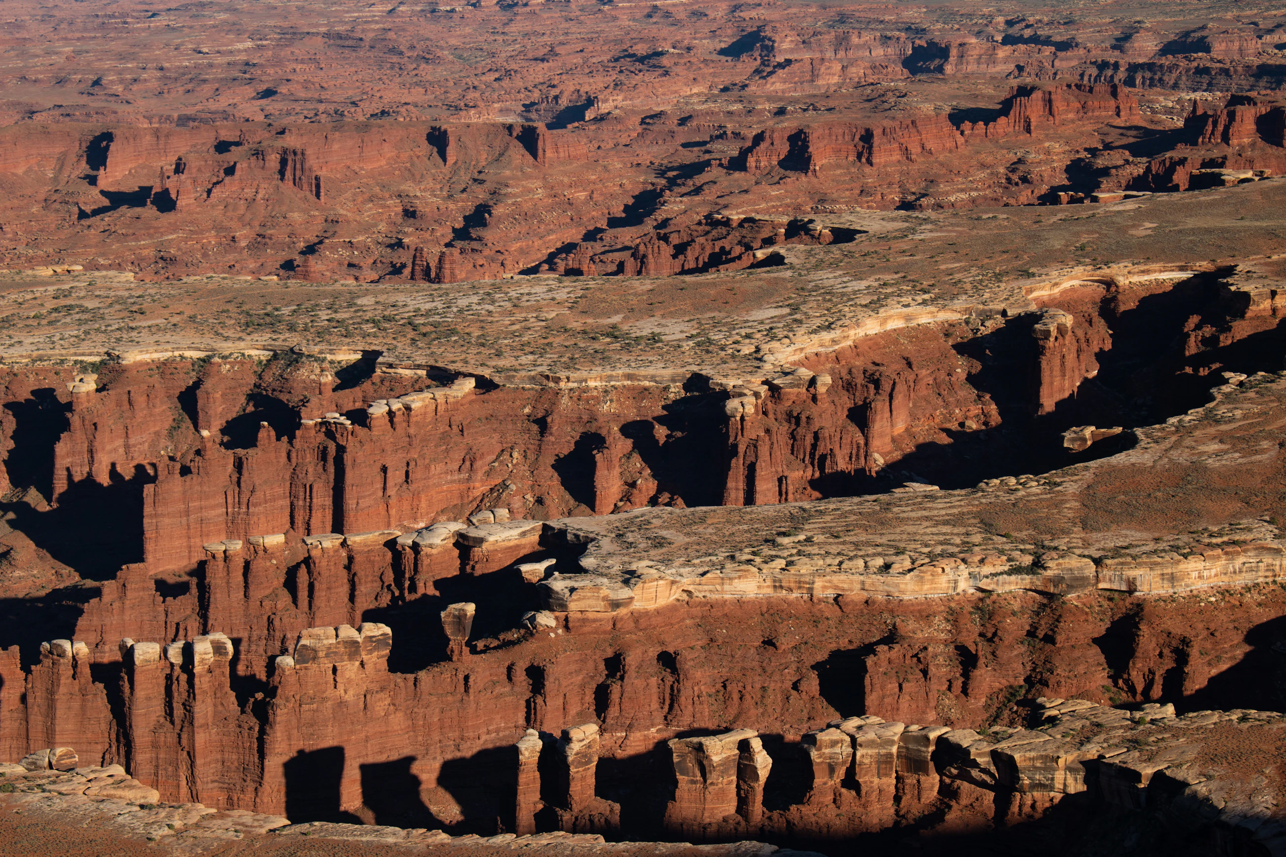 An aerial view of a canyon carved through desert terrain