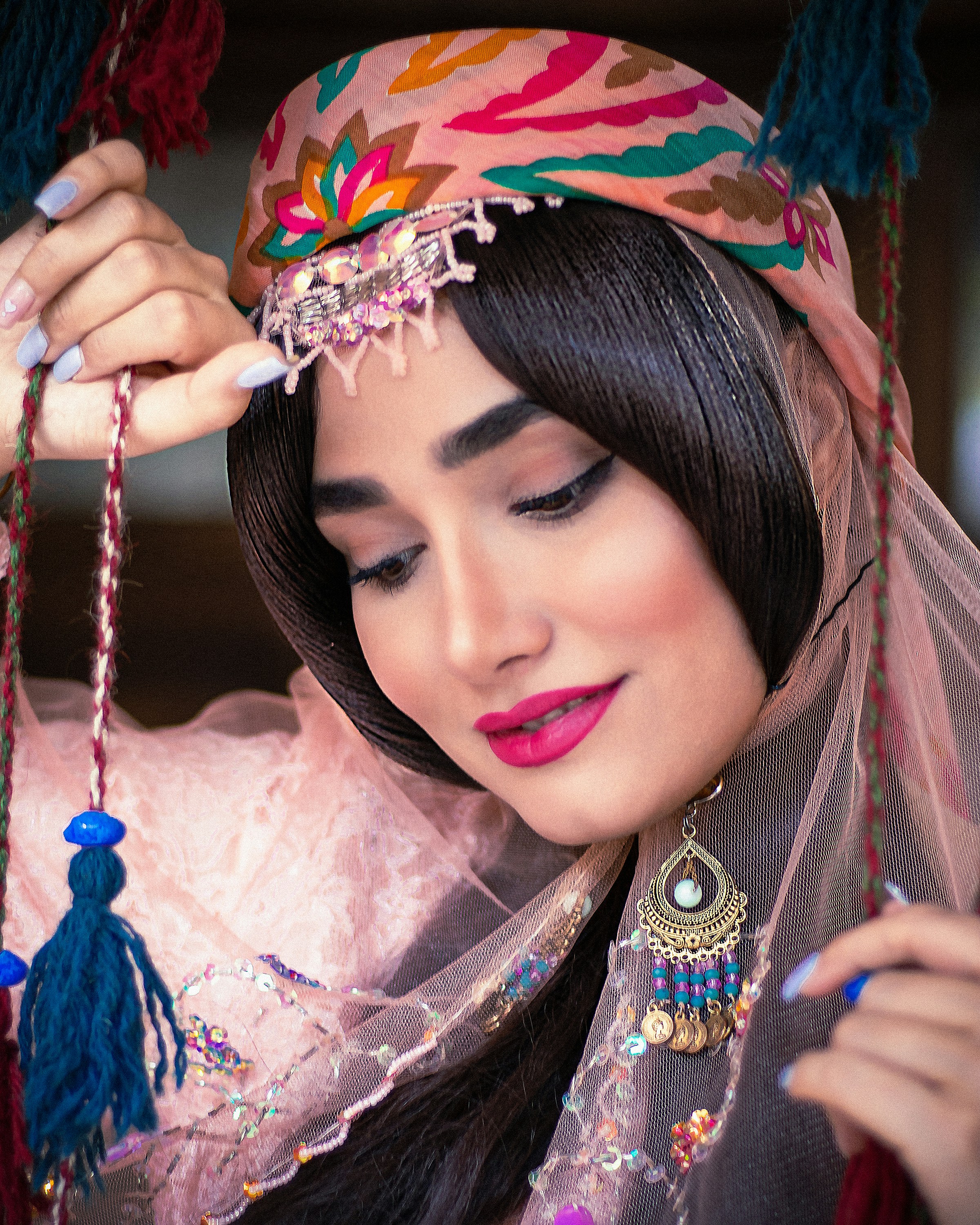 Seorang wanita mengenakan kerudung dan penutup kepala berwarna-warni