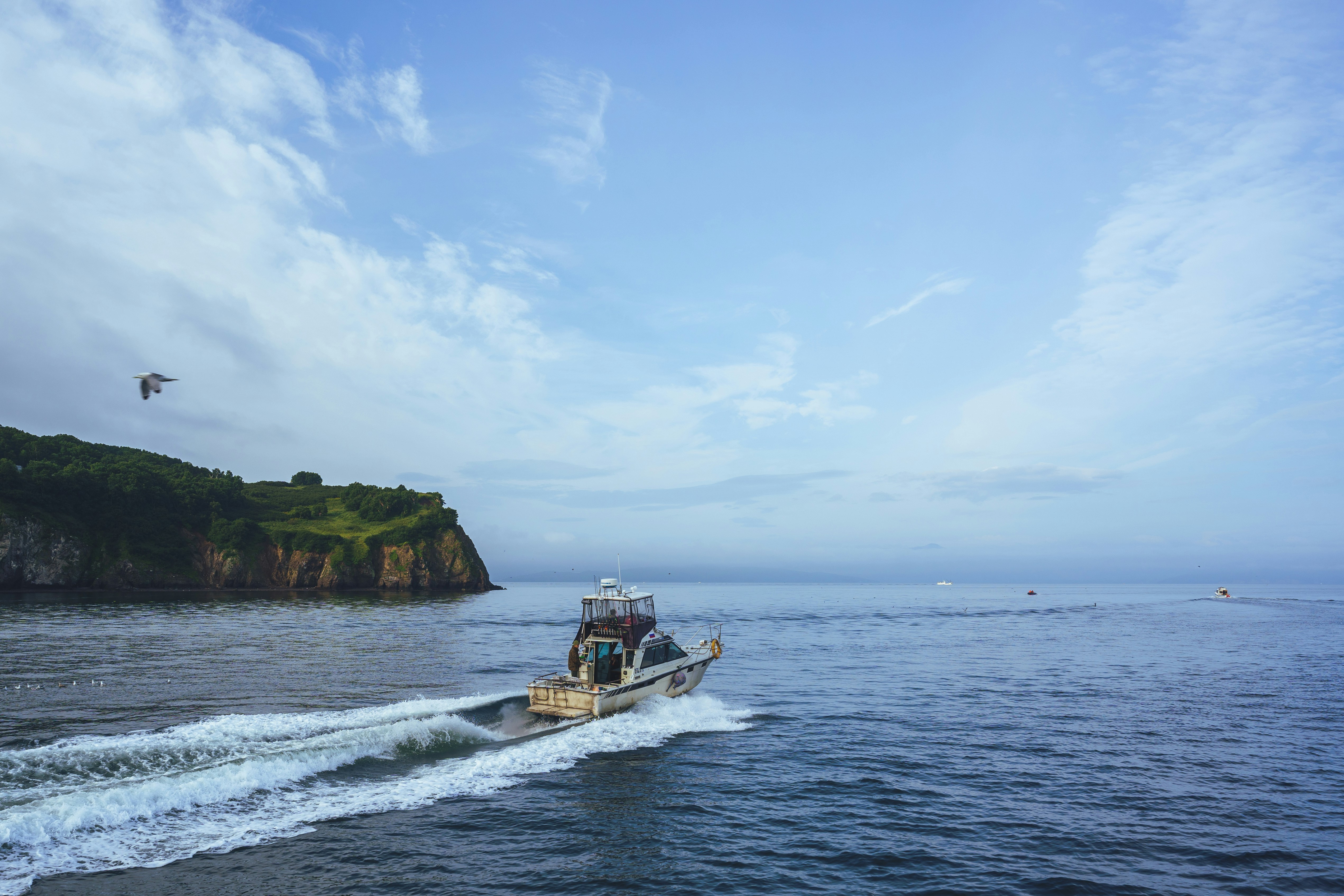 A small boat traveling across a large body of water