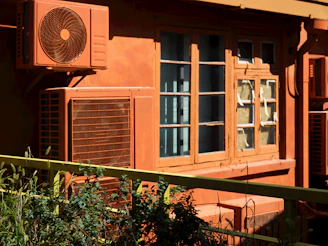 An orange building with a fan on the side of it