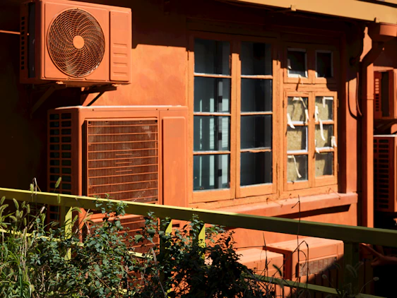 An orange building with a fan on the side of it