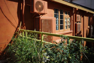A red building with a window and a green fence