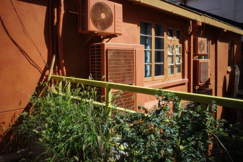 A red building with a window and a green fence