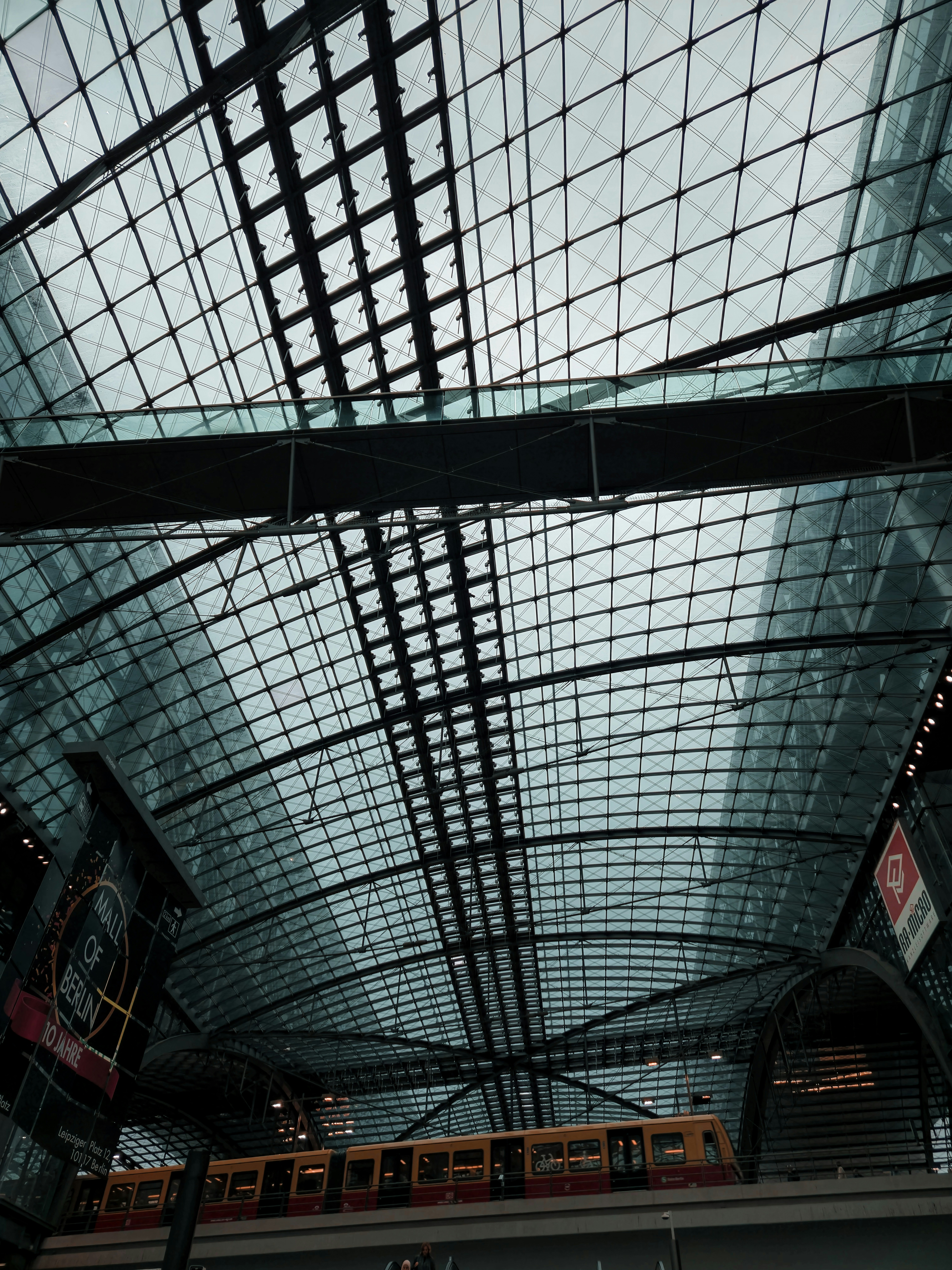 The ceiling of a train station with a train on the tracks