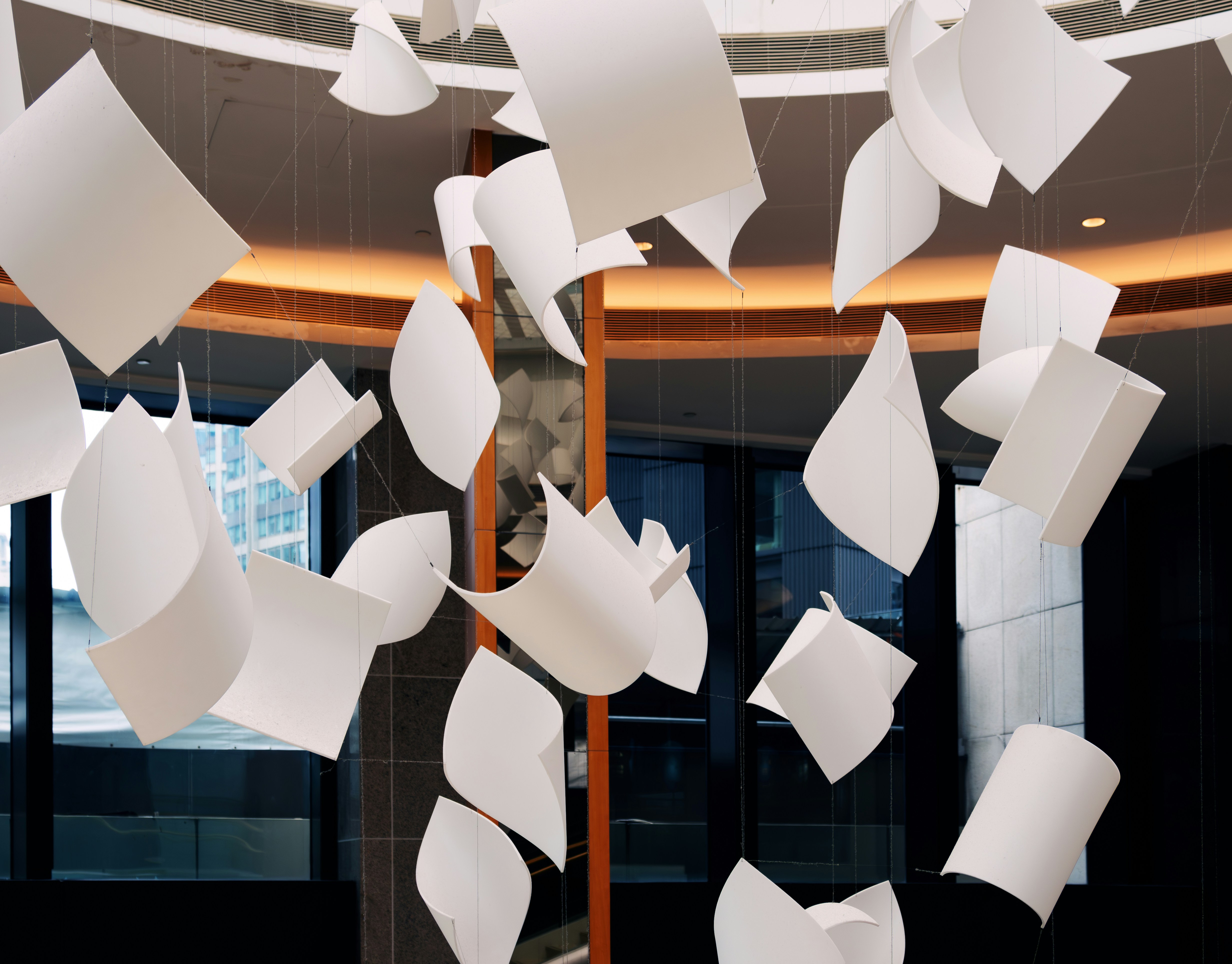 A room filled with lots of white paper flying through the air