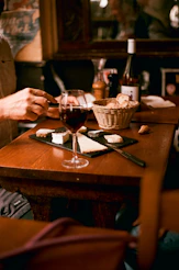 A man sitting at a table with a glass of wine