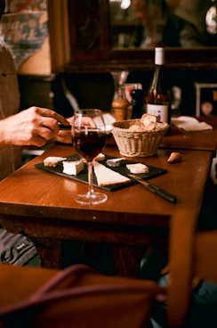 A man sitting at a table with a glass of wine