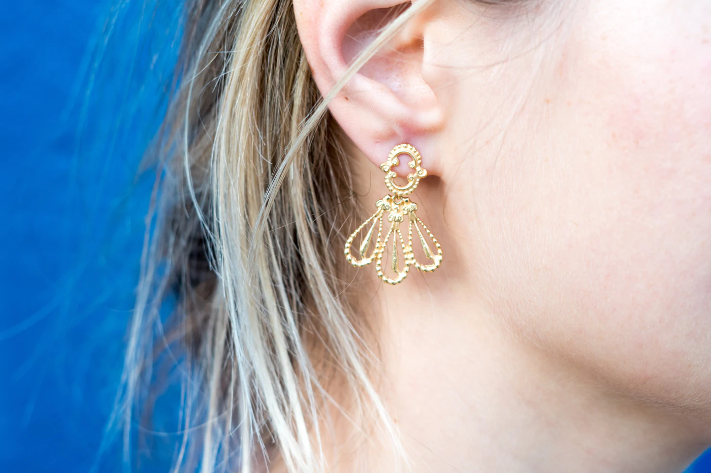 Close up of a person wearing small earrings in a healed piercing