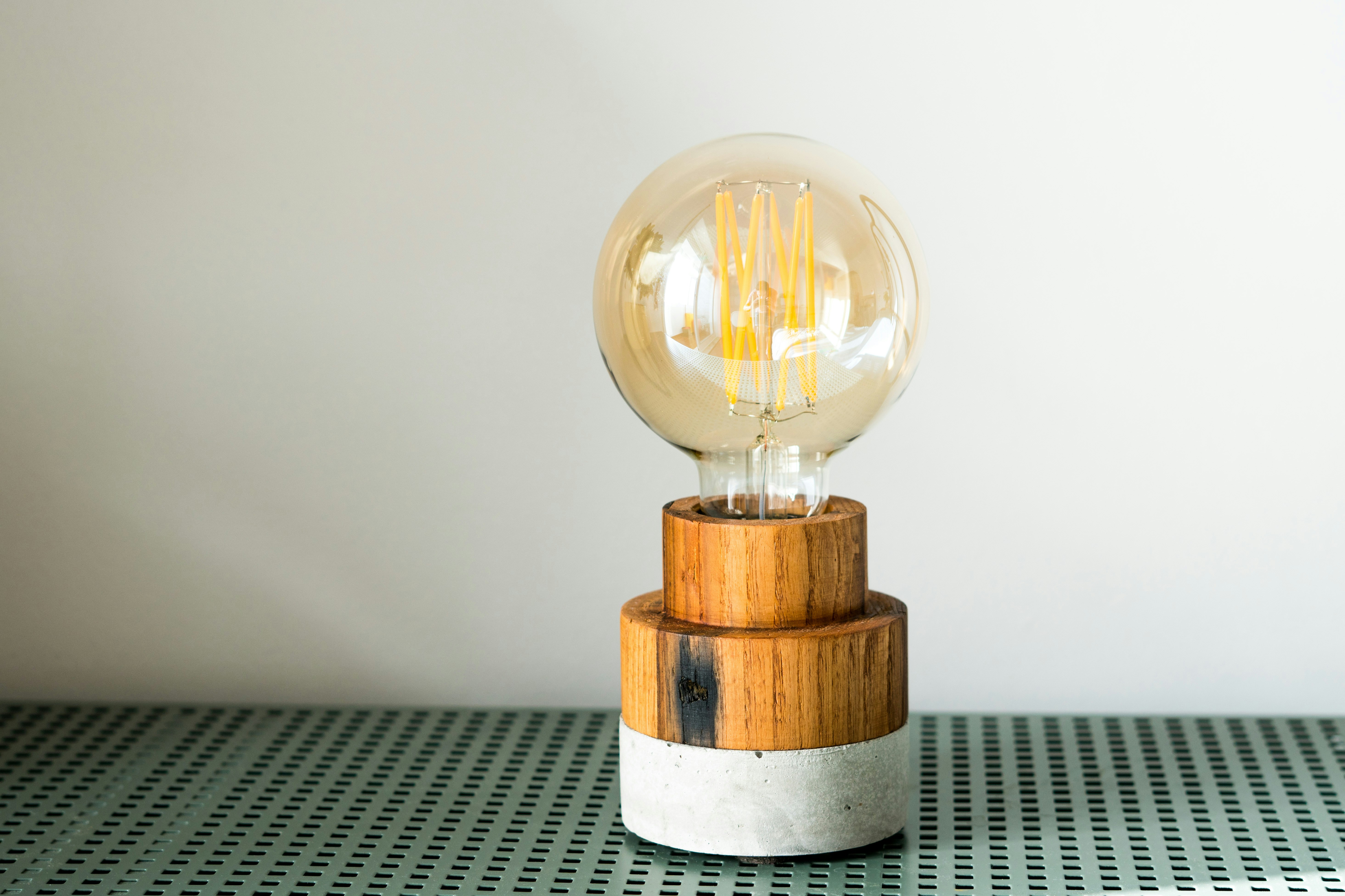 A light bulb sitting on top of a wooden stand
