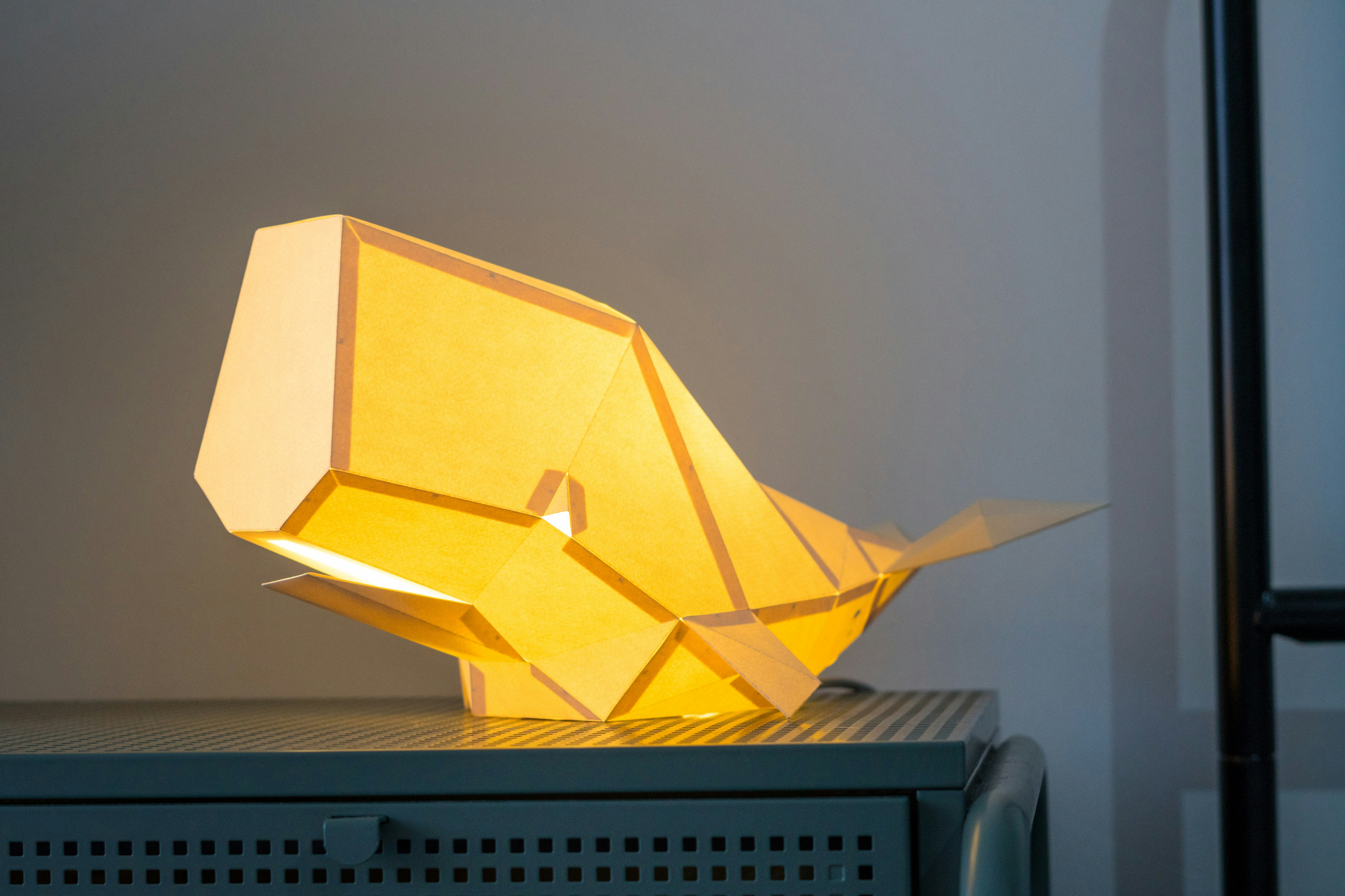 A yellow origami lamp sitting on top of a table