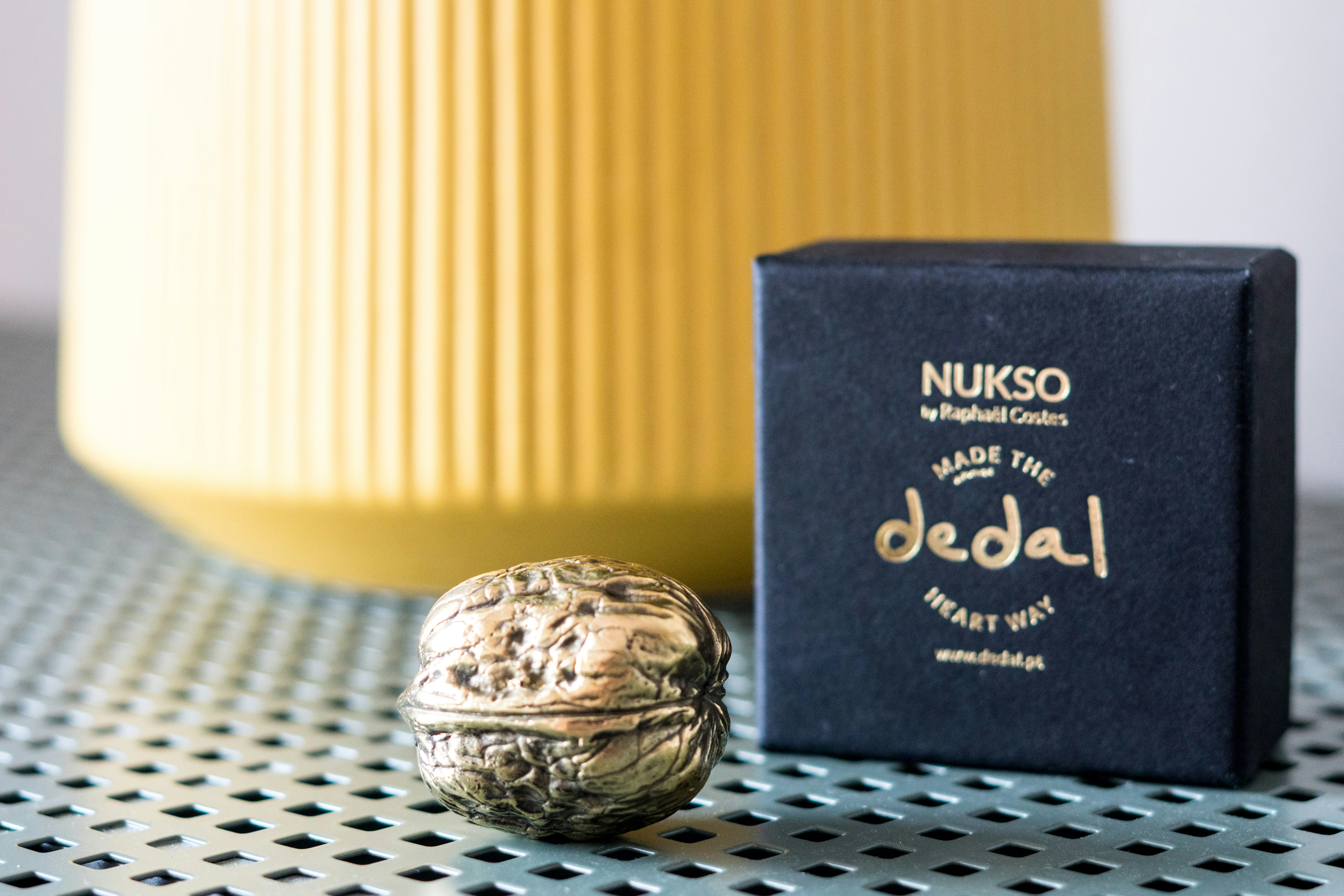 A black box sitting on top of a table next to a yellow vase