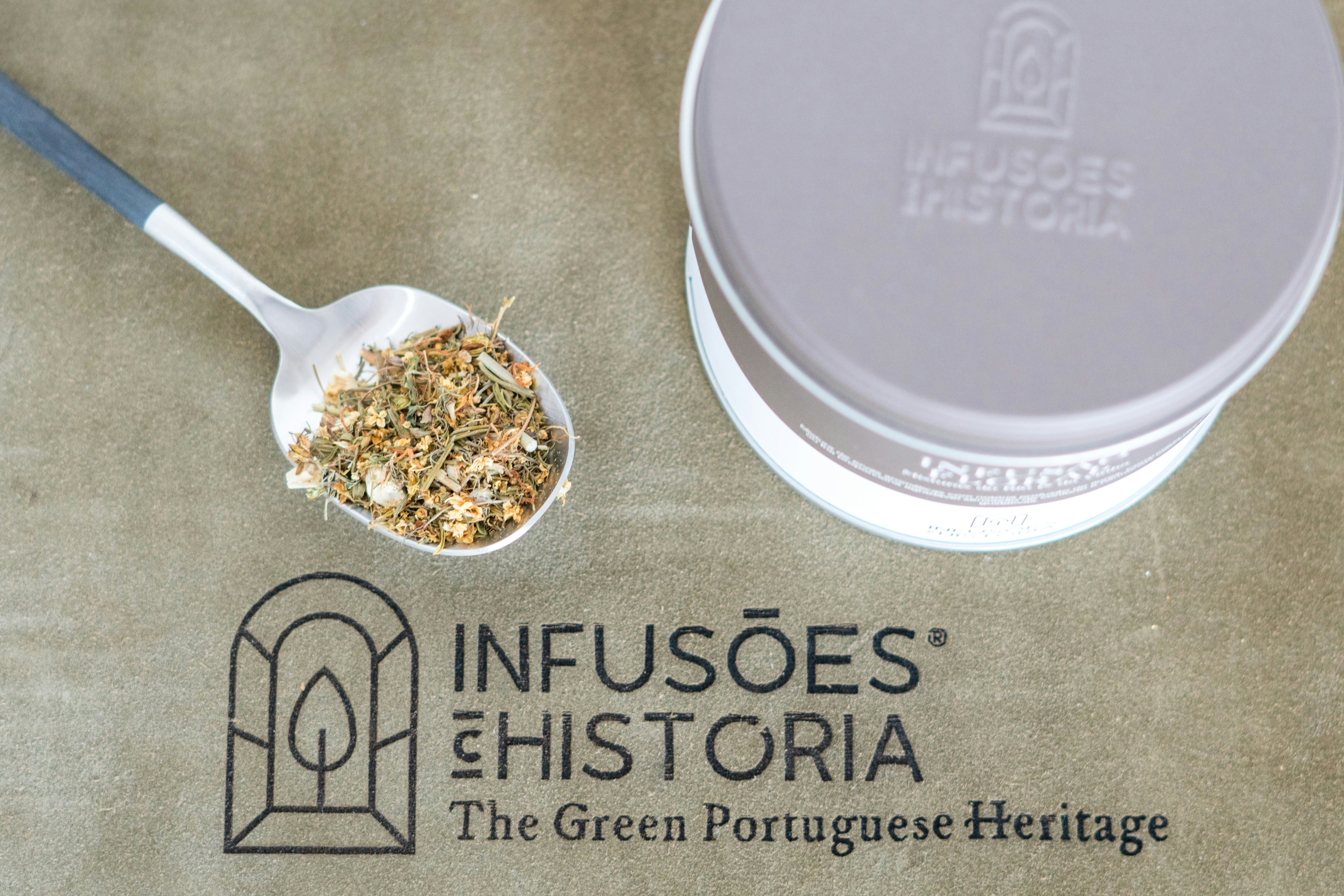 A spoon with granola in it next to a tin of granola