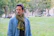 A man standing in a park with a scarf around his neck