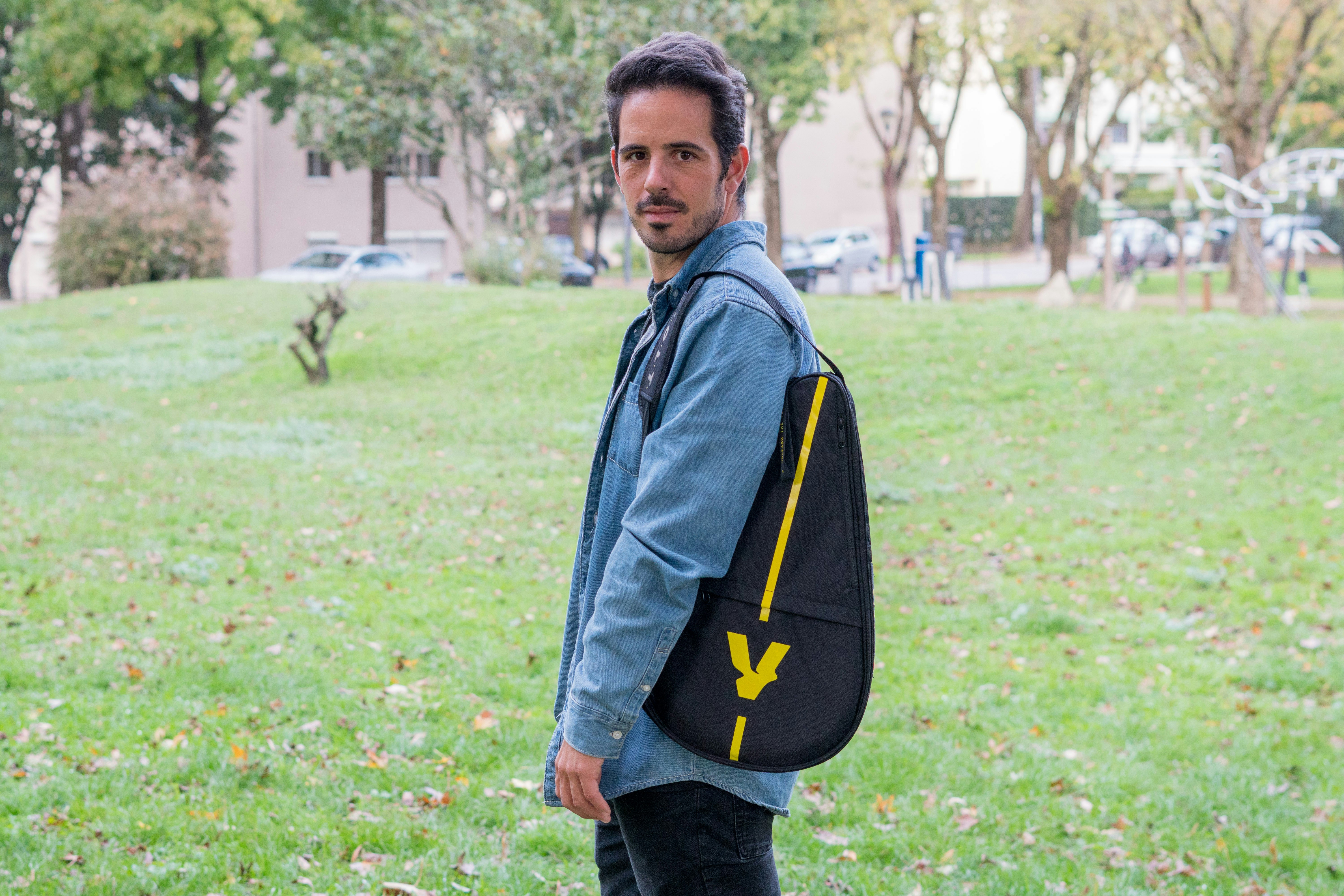 Ein Mann steht mit einem Rucksack auf dem Rücken in einem Park