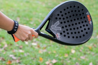 A close up of a person holding a tennis racket