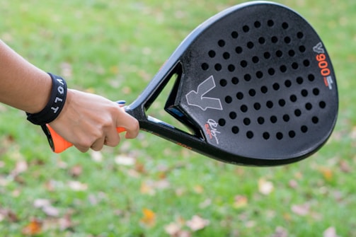 A close up of a person holding a tennis racket
