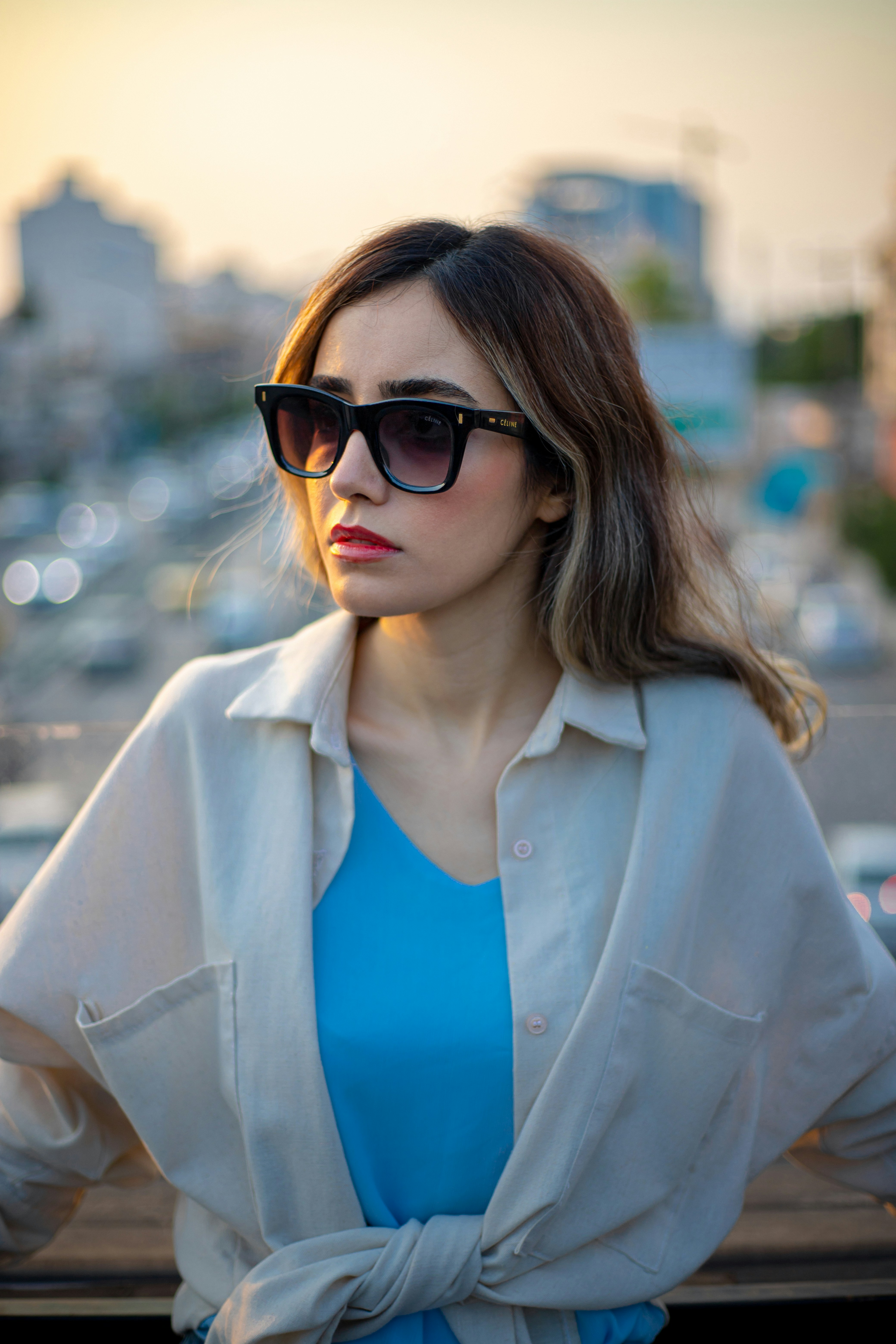 A woman wearing sunglasses and a blue shirt