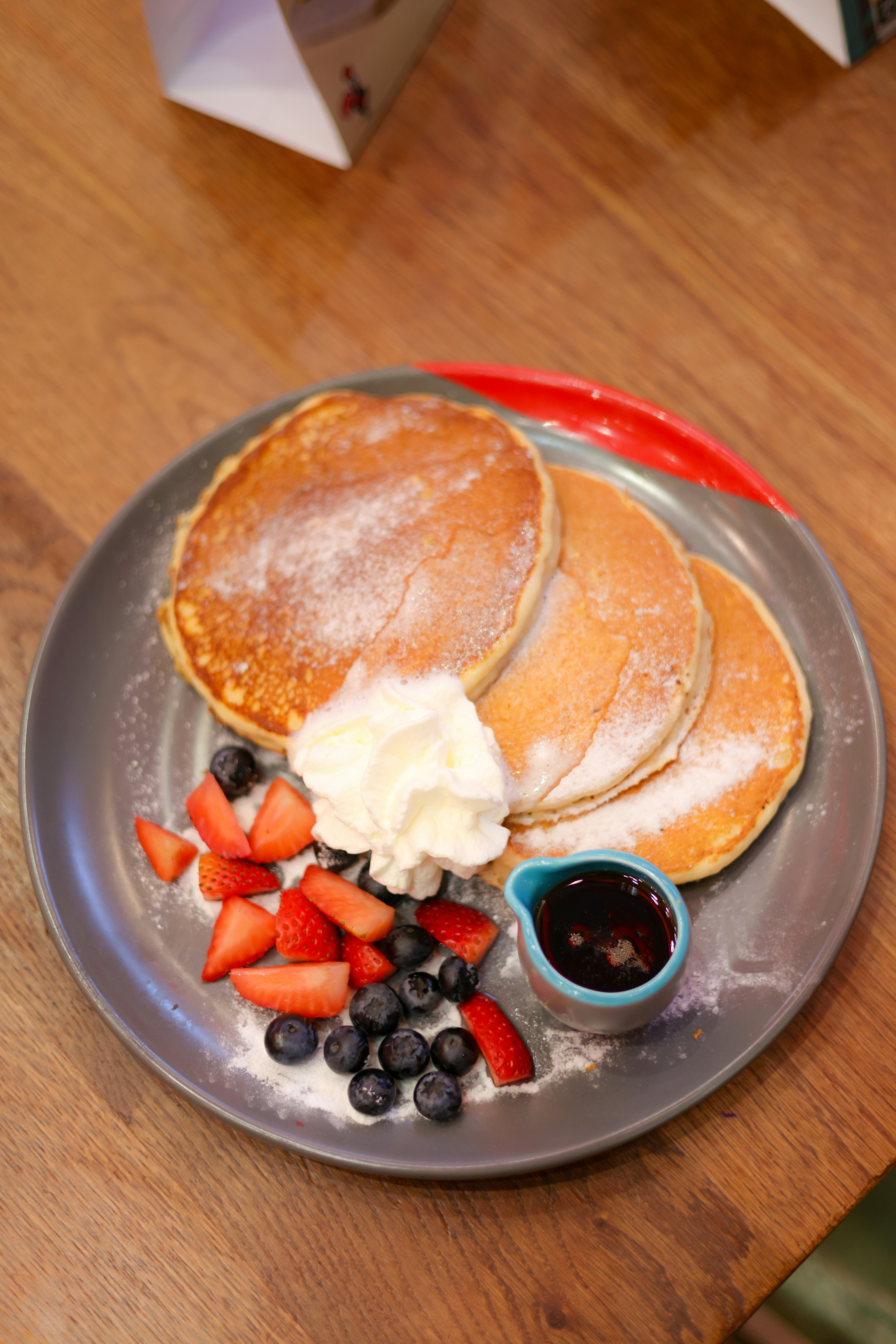 A plate of pancakes, berries, and butter on a table