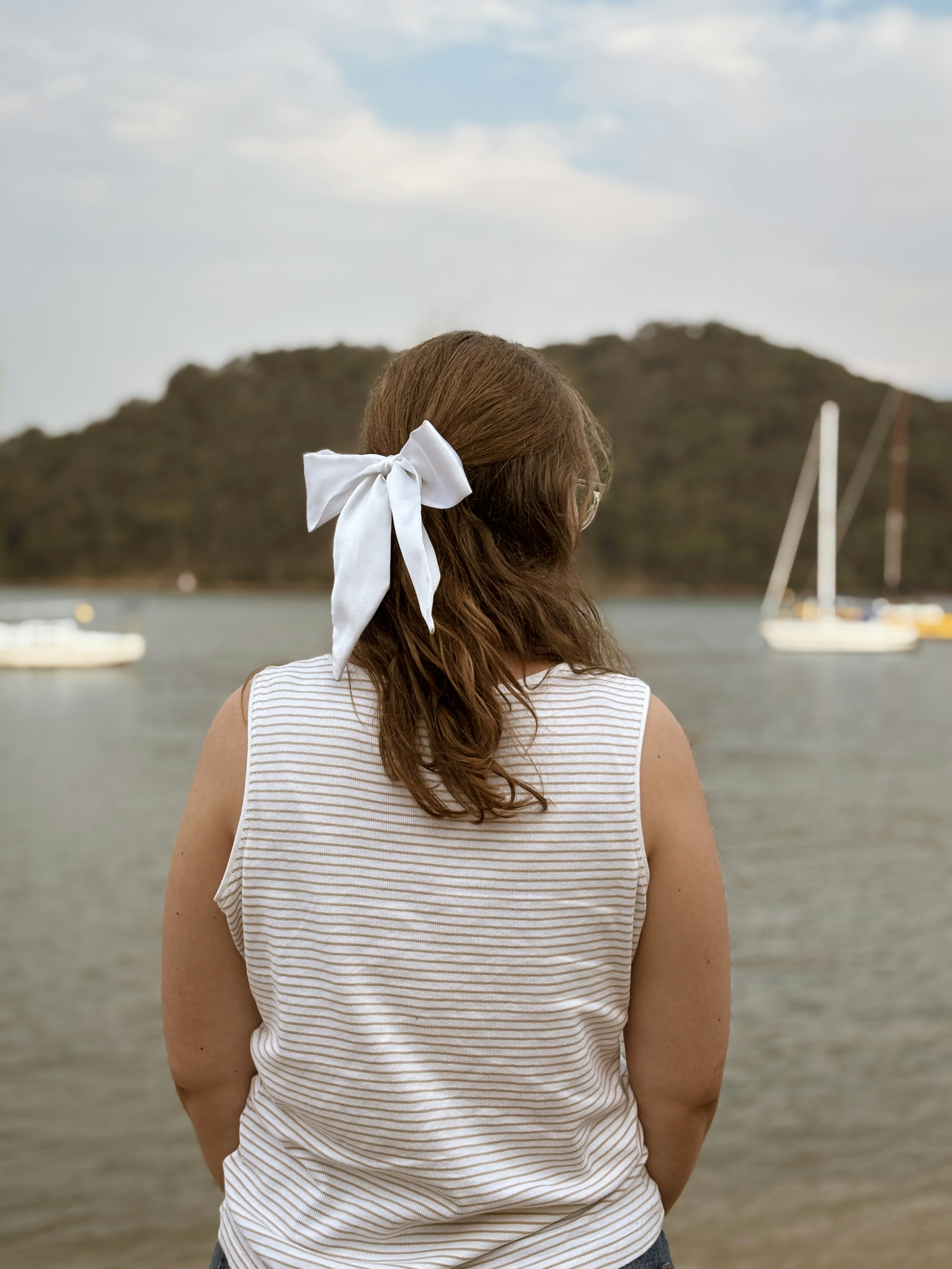 Una mujer de pie frente a un cuerpo de agua