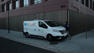 A white van parked next to a tall building