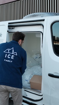 A man unloading a white van with the door open