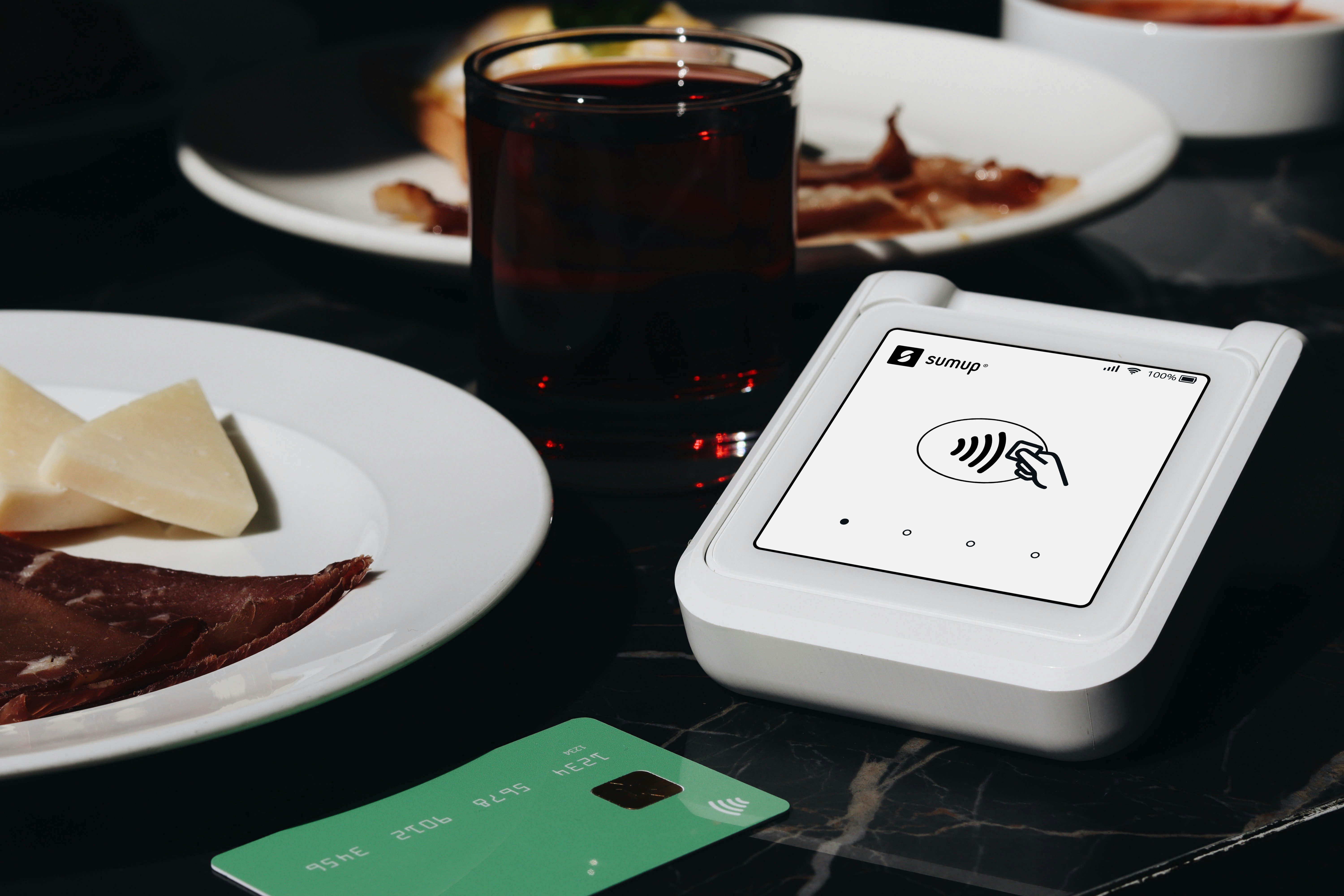 A table topped with plates of food and a smart device