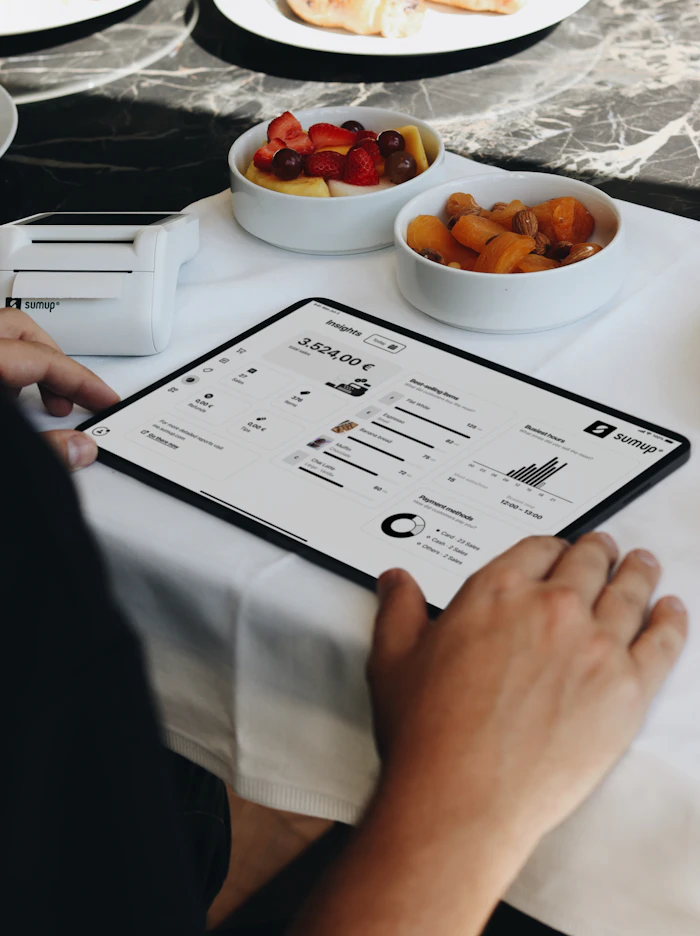 Restaurantmitarbeiter verwaltet Tischreservierungen auf einem Tablet